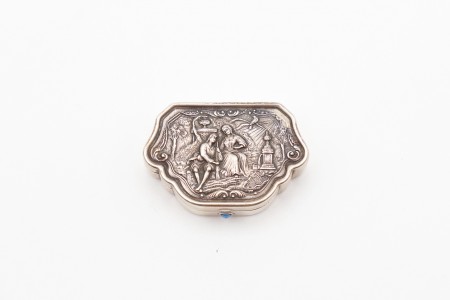 Caixa de comprimidos em prata com cena idílica e elementos vegetalistas relevado